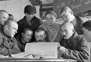 Members of the “Rot Front” collective farm read about a government decree on purchase in the Nachrichten newspaper [which was the main newspaper of the Volga German region in German language], 1932.