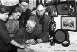 Семья немецких колхозников в домашнем быту вечером, пишут письмо. 1932 г.